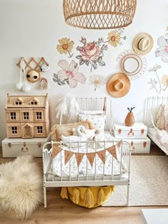 a white bed sitting in a bedroom next to a wall with lots of flowers on it