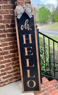 a sign that says hello on it next to a brick wall and black iron fence