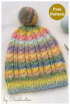 a multicolored knitted hat with a ball of yarn next to it