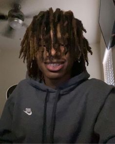 a man with dreadlocks wearing a nike hoodie