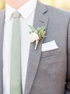 a man in a suit and tie with a boutonniere on his lapel