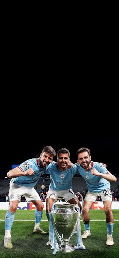 three soccer players are posing for a photo with the trophy in front of their heads