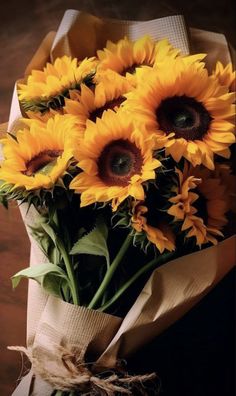 a bouquet of sunflowers wrapped in brown paper