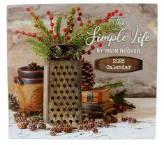 the simple life by irvin hover calendar is displayed with pine cones and red berries