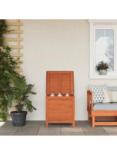 a wooden bench sitting on top of a patio next to a potted plant and window