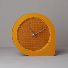 an orange clock sitting on top of a table