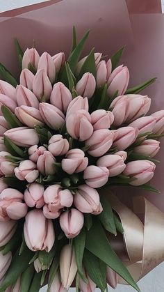 a bouquet of pink tulips with green leaves