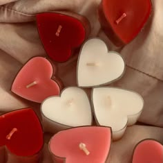 several heart shaped candles sitting on top of a bed