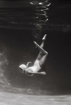 a man in white swimsuit diving under water