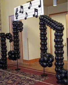 some black balloons that are in the shape of musical notes and trebles on them