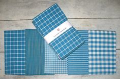 blue and white checkered cloths laid out on a wooden surface with one folded in half