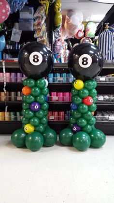 two balloons are made to look like billiards with balls on their heads and numbers