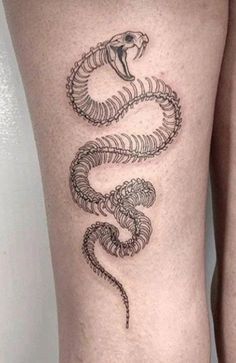 a woman's thigh with a snake tattoo on it