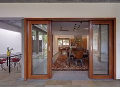 an open door leading into a dining room and kitchen area with glass doors on both sides