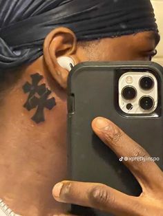 a close up of a person holding a cell phone in front of their face with an ear piercing