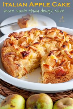 an apple cake on a white plate next to some apples