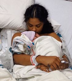 a woman laying in a hospital bed with her arm wrapped around an iv drip tube