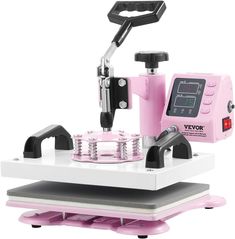 a pink and white machine sitting on top of a table next to a black object