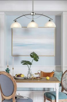 a dining room with blue chairs and a painting hanging on the wall above it's table