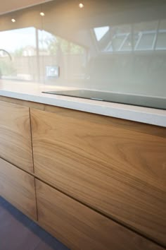 a close up of a kitchen counter top with wood grained finish and glass on the back