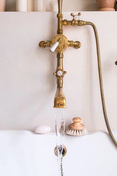 a faucet with water running from it and seashells in the background