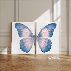 two blue and pink butterflies on white canvases in an empty room with parquet flooring