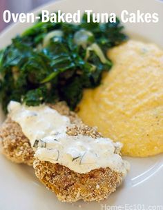 there is a white plate with breaded tuna cakes and spinach leaves on it