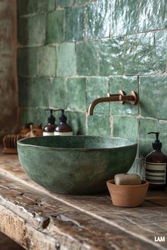 a green bowl sink sitting on top of a wooden counter