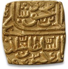 an ancient gold seal with arabic writing on it's sides and two birds in the middle