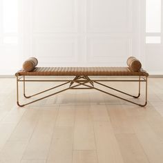 a bench sitting on top of a hard wood floor next to a white wall in an empty room