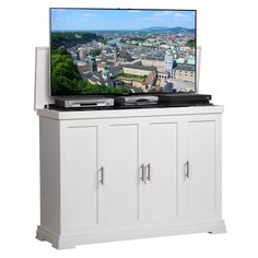 a flat screen tv sitting on top of a white cabinet