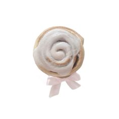 a white frosted donut with a pink bow on it's side, against a white background