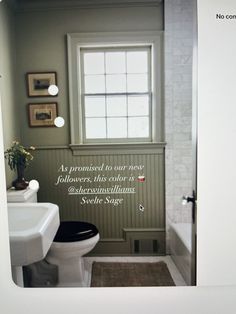 a white toilet sitting next to a sink in a bathroom under a window with a quote on the wall