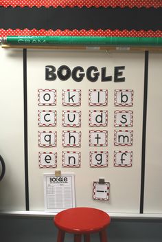 a bulletin board with the word boggle written on it and a red stool next to it