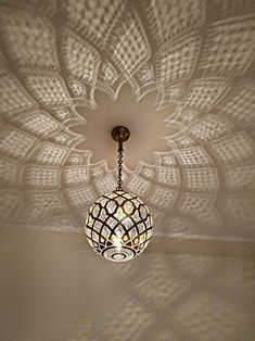 a chandelier hanging from the ceiling in a room with white walls and ceilings