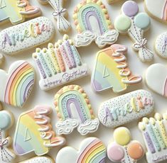 decorated cookies with rainbows, clouds, and balloons on top of a white surface