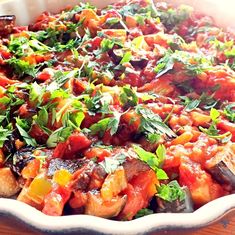 a casserole dish filled with lots of food on top of a wooden table