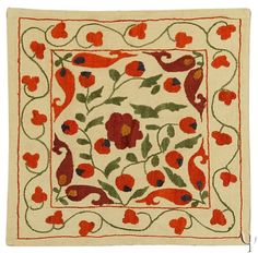 an embroidered square with red flowers on it