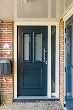 a blue front door with two sidelights on the brick wall next to a mailbox