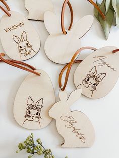 four wooden tags with hand drawn rabbits on them, one has a name and the other has an image of a rabbit