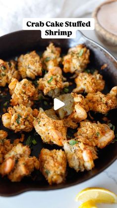 crab cake stuffed shrimp in a skillet with lemon wedges