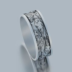 a wedding ring with an intricate design on the outside and inside, in white gold