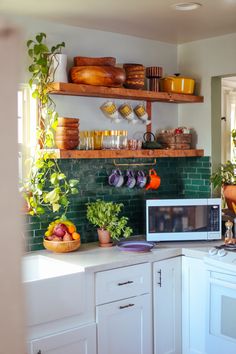 the kitchen is clean and ready for us to use it's shelves are filled with dishes