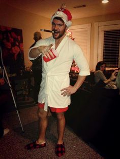 a man dressed up in a towel and santa hat with his hands on his hips