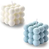 two candles that are sitting side by side on a white surface, one is blue and the other is white