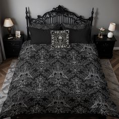 a black and white bed in a bedroom next to two nightstands with lamps on each side