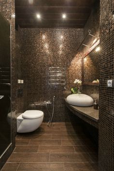 a bathroom with two sinks and a large mirror above the sink is tiled in brown tones