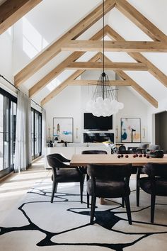 a large dining room with wooden beams and black chairs