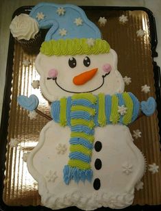 a frosted snowman cake sitting on top of a pan