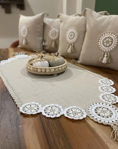 a pair of shoes sitting on top of a wooden table next to pillows and tassels